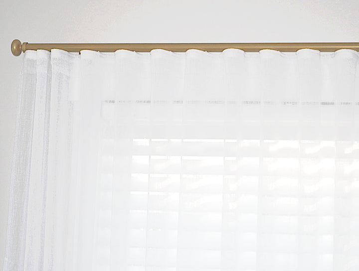 Gold curtain track with white linen sheers
